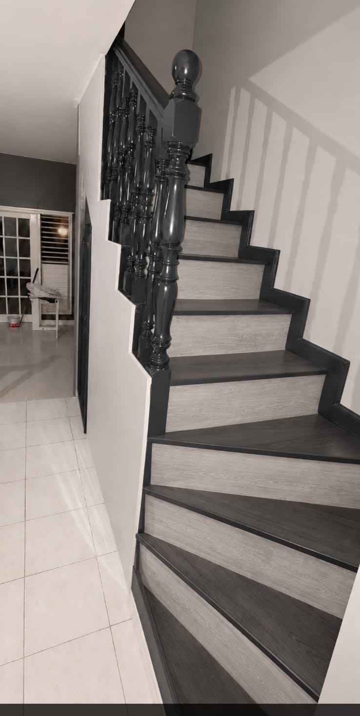 Staircase finished in grey wood-effect treads with gloss charcoal balustrade